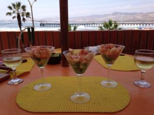 a table with three wine glasses with fruit in them at Bungalows Cerro Azul in Cerro Azul