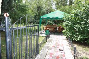a fence with a table and a green umbrella at Vydubychi in Kyiv