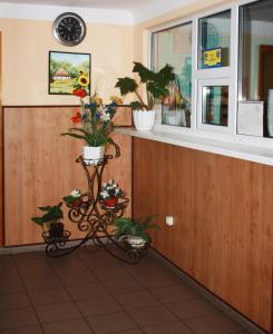 a waiting room with a counter with plants and a clock at Vydubychi in Kyiv