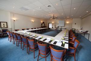 una gran sala de conferencias con una mesa larga y sillas en Fletcher Hotel Restaurant Veldenbos, en Nunspeet