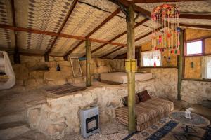 ein Zimmer mit einem Sofa in einem Steingebäude in der Unterkunft Succah in the Desert in Mitzpe Ramon