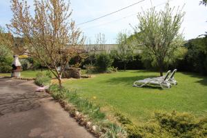 Granges-sur-VologneにあるLa Boulangerieの芝生の白いベンチのある庭