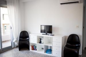 a living room with two black chairs and a tv at MyFlats Voramar in El Campello