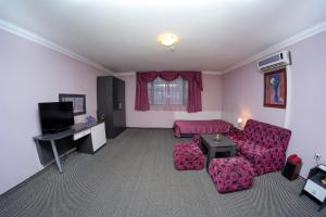 a living room with a couch and a table at Haskovo Hotel in Haskovo