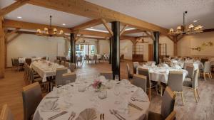 a dining room with tables and chairs with white tablecloths at Gasthaus Forster am See - Eching bei Landshut in Eching