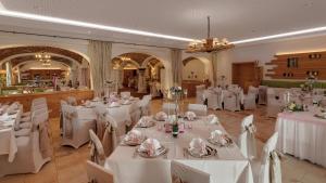 un salón de banquetes con mesas blancas y sillas blancas en Gasthaus Forster am See - Eching bei Landshut, en Eching