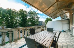 d'une terrasse avec une table et des chaises en bois sur un balcon. dans l'établissement Kreschatik 21 with terrace 2BR, à Kiev