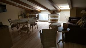 ein Wohnzimmer mit einem Tisch, Stühlen und einem Sofa in der Unterkunft El Encanto del Moncayo in Ágreda