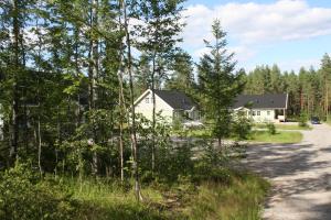 a house in the woods next to a road at Surkeenjärven Jaakon talot in Moksinkylä