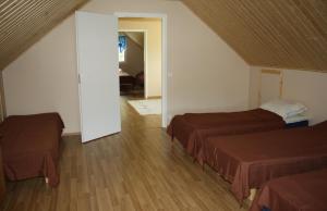 a bedroom with two beds and a door to a room at Surkeenjärven Jaakon talot in Moksinkylä