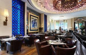 a restaurant with tables and chairs and a chandelier at Hotel Eclat Taipei in Taipei