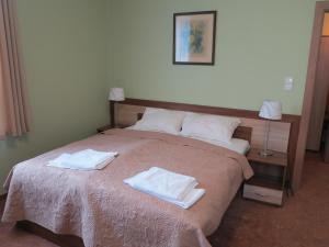 1 dormitorio con 1 cama grande y 2 toallas. en RoFel Pokoje Gościnne, en Sopot