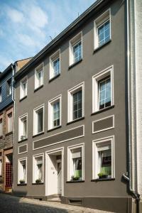 a gray building with white windows on a street at Zimmer am Markt in Traben-Trarbach