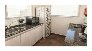 a small kitchen with a refrigerator and a sink at Casa Ba Haus in Puerto Pirámides