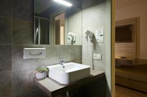 La salle de bains est pourvue d'un lavabo blanc et d'un miroir. dans l'établissement Locanda Benetti, à Costabissara