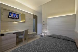 a bedroom with a bed and a desk and a television at Locanda Benetti in Costabissara