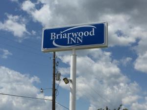 a blue and white sign on a pole at Briarwood Inn in Amory