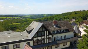 an aerial view of a house with mountains in the background at Landhotel Fernblick in Hümmerich