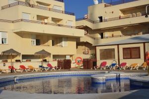 una piscina di fronte a un edificio di Apartamentos Turisticos Caños de Meca a Los Caños de Meca