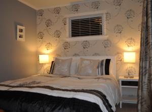 a bedroom with a large bed with two lamps at 16 Havelock in New Plymouth
