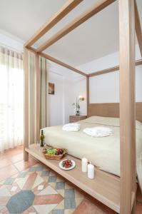 a bedroom with a canopy bed with a tray of food at Astir Of Naxos in Naxos Chora