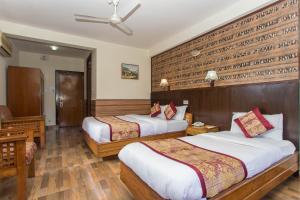 Uma cama ou camas num quarto em Hotel Tulsi