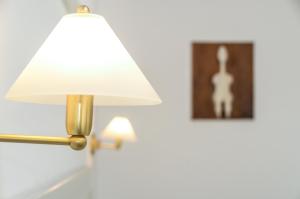a gold lamp with a white shade and a picture at Astir Of Naxos in Naxos Chora