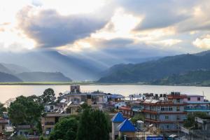 a city with buildings and a lake and mountains at Hotel Tulsi in Pokhara
