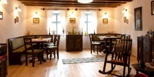 a dining room with tables and chairs and windows at Casa cu zorele, Crit 189 in Criţ