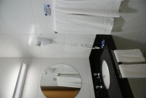 La salle de bains est pourvue d'un miroir et de serviettes blanches. dans l'établissement Cristal Palace Inn, à Lins