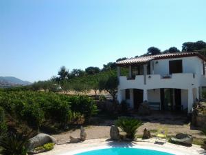 a villa with a swimming pool in front of a house at Agriturismo B&B Domo De Resteblas in Berchidda