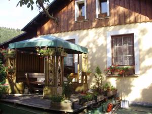 a house with a deck with a table and an umbrella at Pension nad Truhlárnou in Svoboda nad Úpou