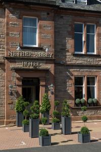 a building with potted plants in front of it at Nether Abbey Hotel in North Berwick