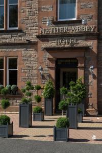 a hotel entrance with potted plants in front of it at Nether Abbey Hotel in North Berwick