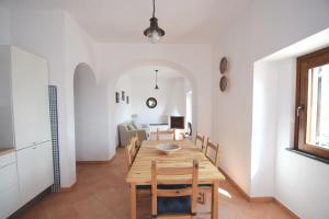 una cucina e una sala da pranzo con tavolo e sedie in legno di Casa della Marina - beach, seaview, wifi a Conca dei Marini