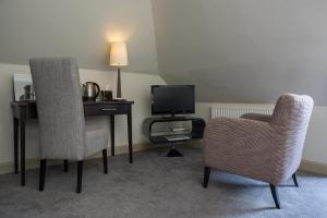 a room with a desk and two chairs and a television at Nether Abbey Hotel in North Berwick