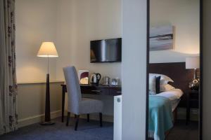 a hotel room with a bed and a desk with a chair at Nether Abbey Hotel in North Berwick