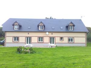 duży dom z dużym zielonym dziedzińcem w obiekcie bnb chambres normandie w mieście Angerville-la-Martel