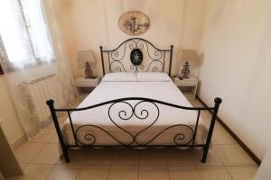 a bed in a bedroom with two tables and two lamps at Locanda del Musso con Ristorante in Adria