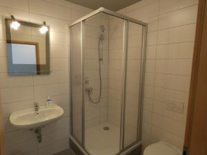 een badkamer met een douche, een wastafel en een toilet bij Pension Take Off in Gera