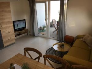 a living room with a couch and a table and a television at Apartmán Dunajky in Dolní Dunajovice