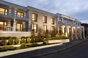 a large white building with bushes in front of it at Esperos Palace Luxury & Spa Hotel in Kastoria