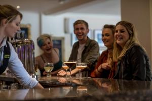 a group of people sitting at a bar with wine glasses at Nether Abbey Hotel in North Berwick