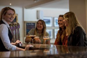 three women sitting at a bar with glasses of wine at Nether Abbey Hotel in North Berwick