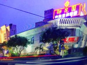 un edificio con una señal de neón en el costado. en 雲林斗六御花園汽車旅館, en Douliu