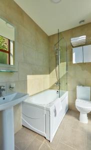 un bagno con vasca, WC e lavandino di Wellotel Yuzhne a Yuzhne