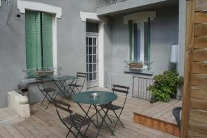 een patio met 2 tafels en stoelen op een balkon bij Appart Albert'House in Clermont-Ferrand