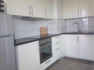 - une cuisine blanche avec évier et cuisinière dans l'établissement Apartment Raversijde with Seaview, à Ostende