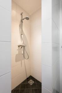 a shower stall with a shower head in a bathroom at Chez Marly in Oosterblokker +15 photos
