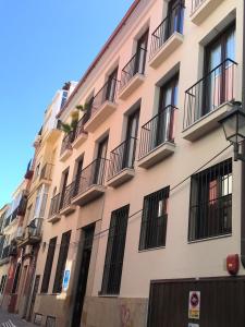 un edificio de apartamentos con balcones en una calle en Málaga Apartamentos - Jinetes, 13, en Málaga